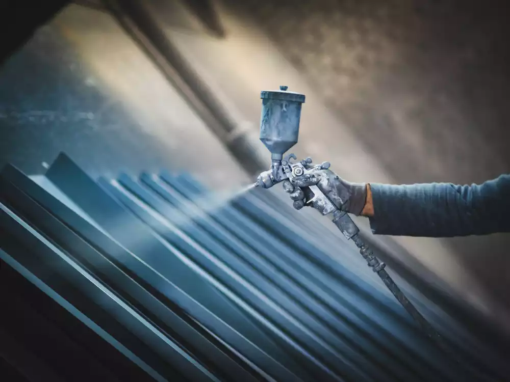 worker using heavy duty equipment paint to protect industrial equipment