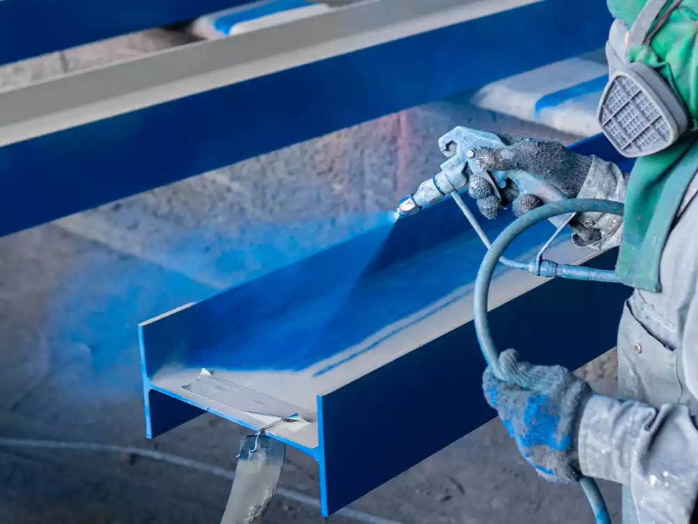 worker using a heavy equipment coating to protect industrial equipment