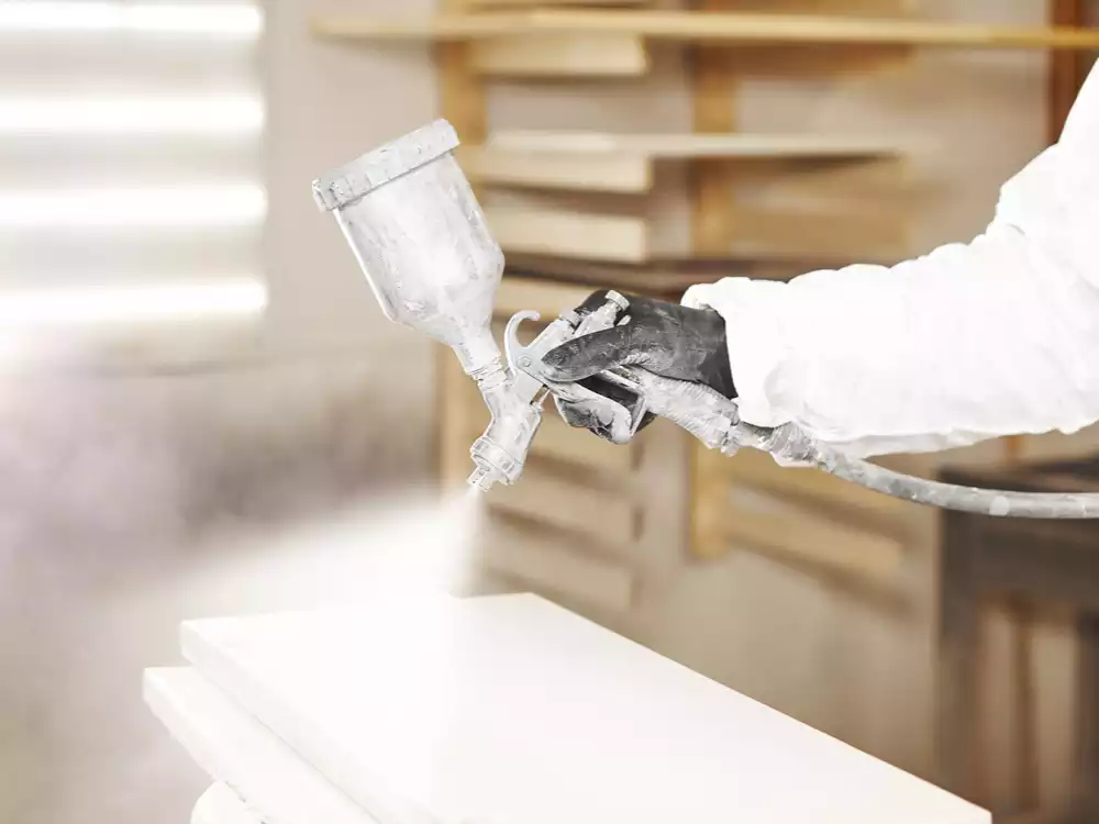 worker using heavy equipment paint to protect industrial equipment