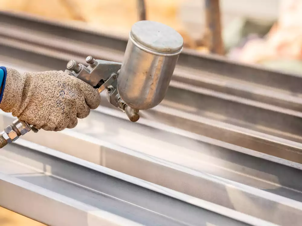 worker using industrial equipment paint to protect industrial equipment